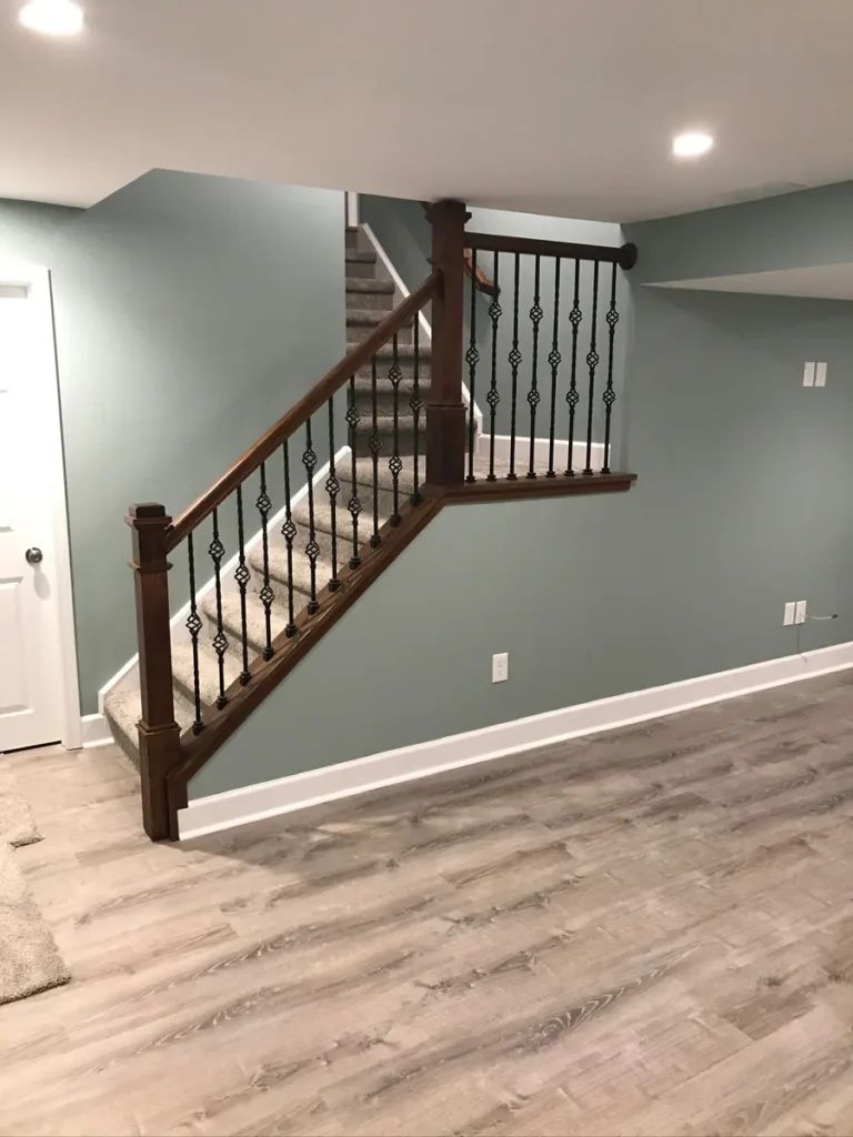 Finished basement staircase with iron balusters and LVP flooring by Edges Unlimited in Clifton Park, NY