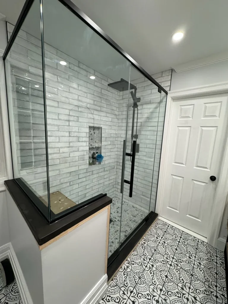 Glass walk-in shower with subway tile and niche by Edges Unlimited in Clifton Park, NY