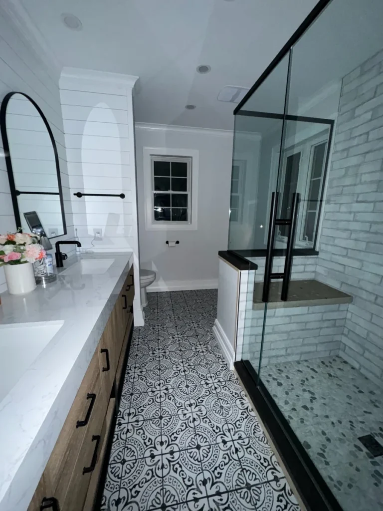 Remodeled bathroom with shiplap walls, glass shower and patterned tile floor by Edges Unlimited in Clifton Park, NY