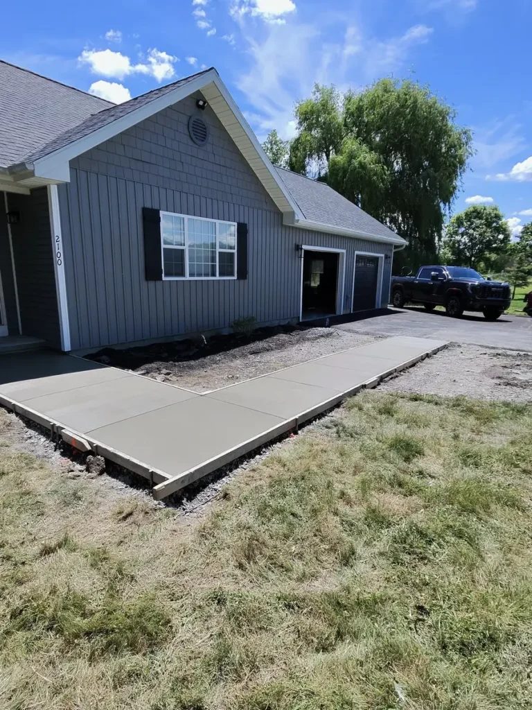Freshly poured L-shaped concrete walkway by Edges Unlimited in Clifton Park, NY