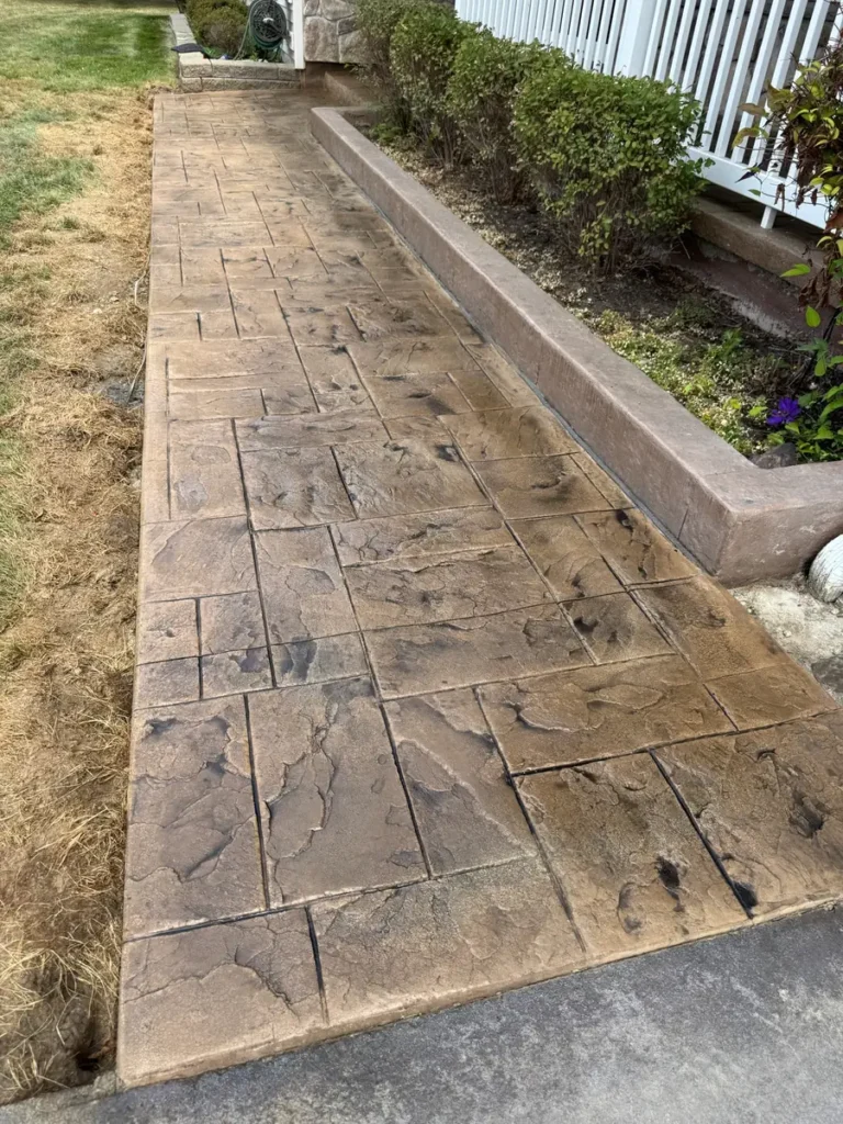 Resealed tan ashlar stamped concrete walkway by Edges Unlimited in Clifton Park, NY