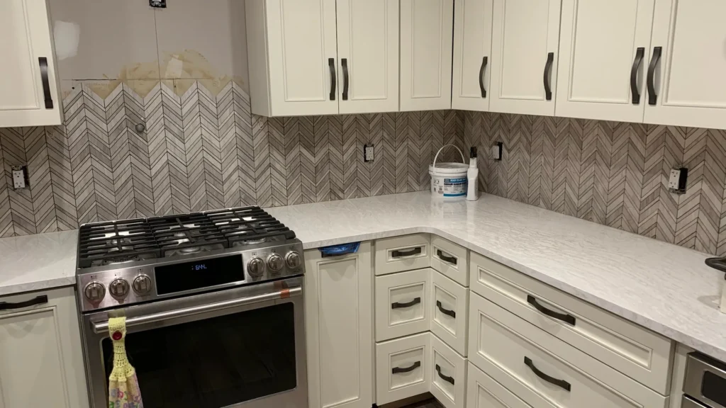 Kitchen remodeling with white cabinets and a quartz island by Edges Unlimited in Clifton Park, NY