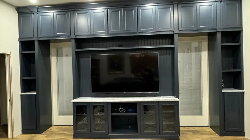 Navy built-in entertainment wall in a finished basement by Edges Unlimited in Clifton Park, NY