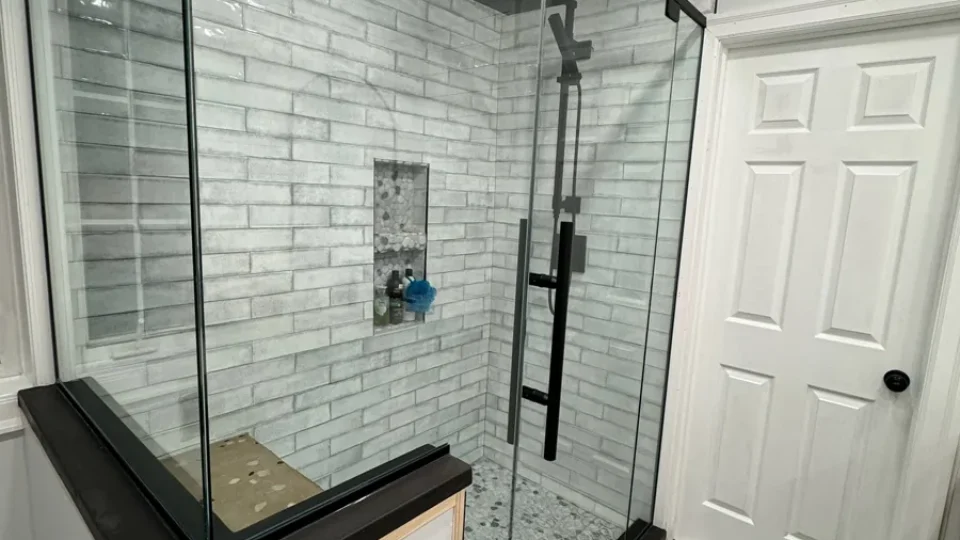 Glass walk-in shower with subway tile and niche by Edges Unlimited in Clifton Park, NY