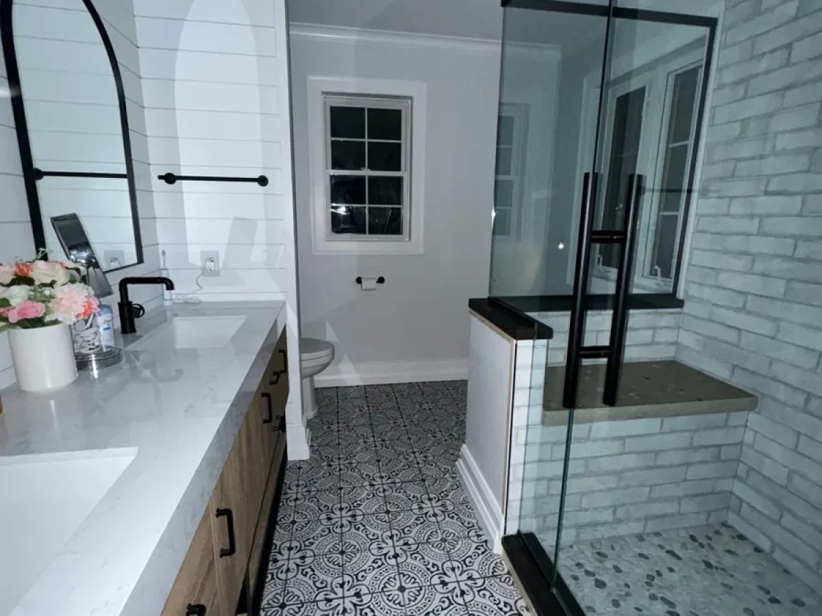 Remodeled bathroom with shiplap walls, glass shower and patterned tile floor by Edges Unlimited in Clifton Park, NY