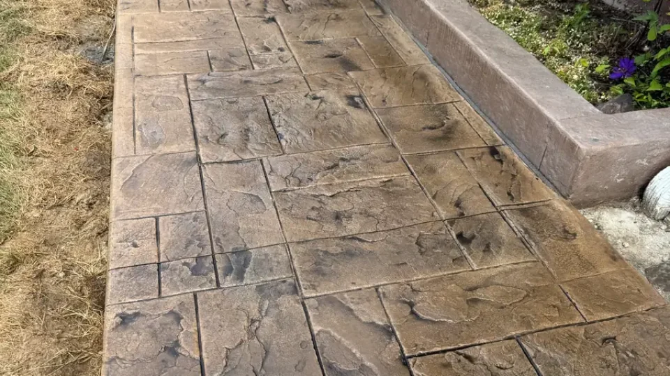 Resealed tan ashlar stamped concrete walkway by Edges Unlimited in Clifton Park, NY