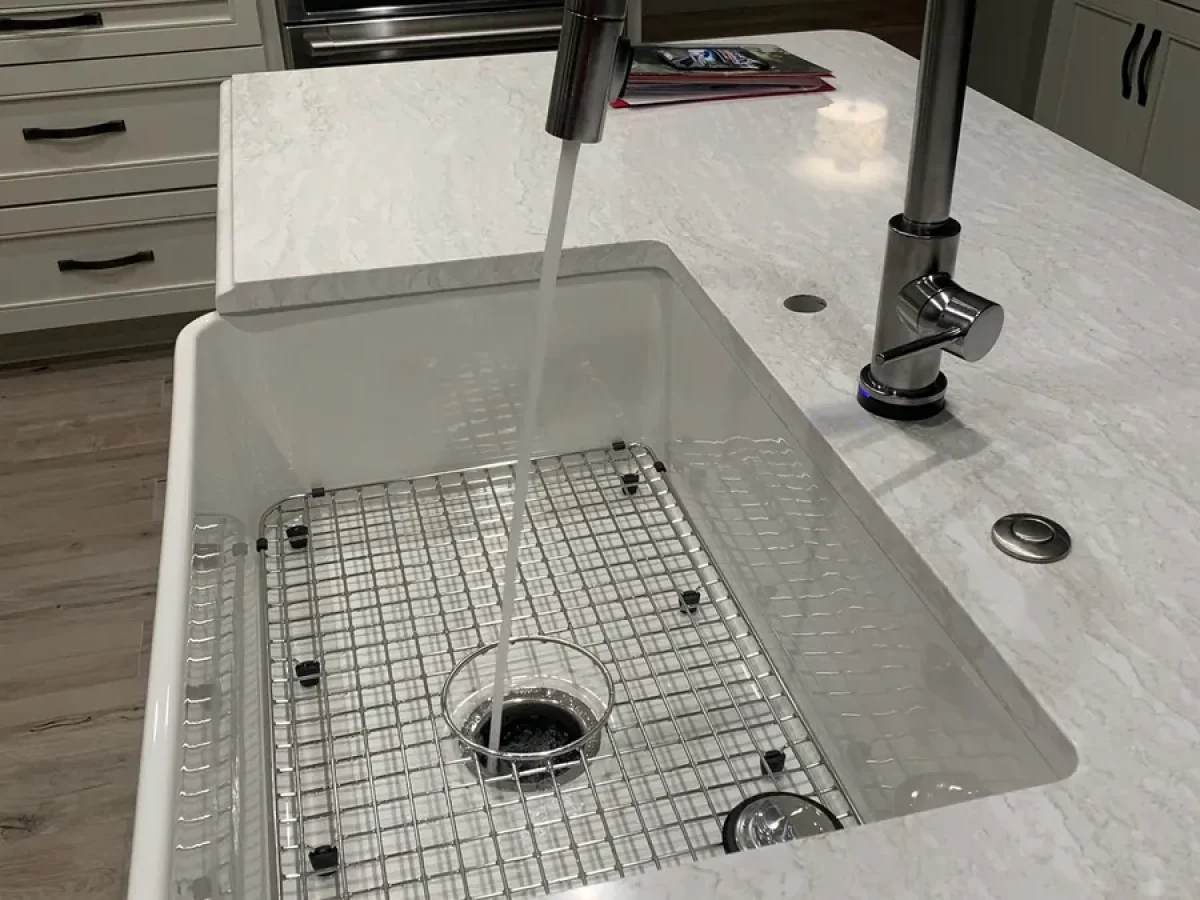 Farmhouse sink and quartz island in a remodeled kitchen by Edges Unlimited in Clifton Park, NY