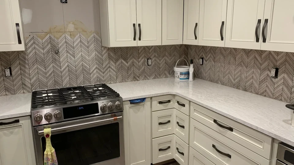 Kitchen remodeling with white cabinets and a quartz island by Edges Unlimited in Clifton Park, NY